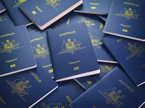 A stack of Australian passports scattered on a surface.